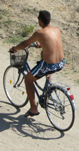 Holiday maker on a bicycle, Nea Vreasna, Greece at The Cheshire Cat Blog