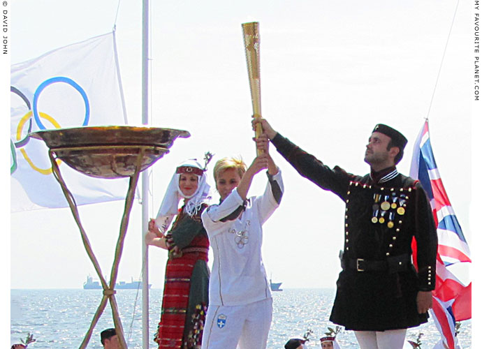 Greek athlete Giota Oikonomou holds her Olympic torch aloft at The Cheshire Cat Blog