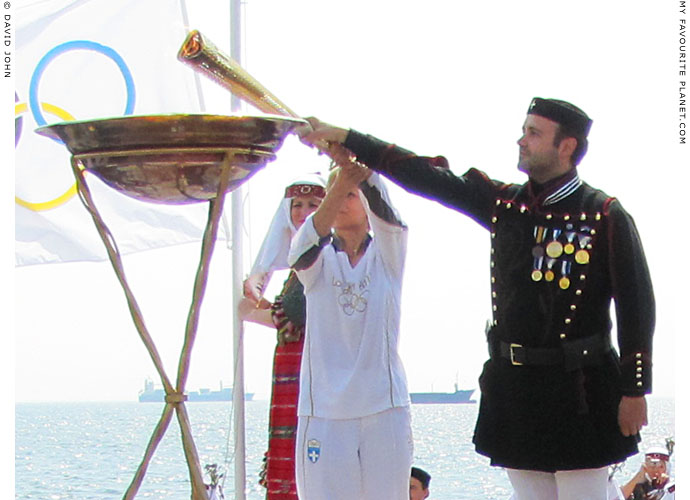 Greek torchbearer Giota Oikonomou lights the Olympic flame in the harbour of Thessalomiki, Macedonia, Greece at The Cheshire Cat Blog