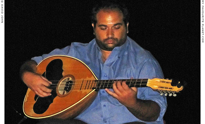 Bouzouki player playing traditional Cretan music in Pella, Greece at The Cheshire Cat Blog