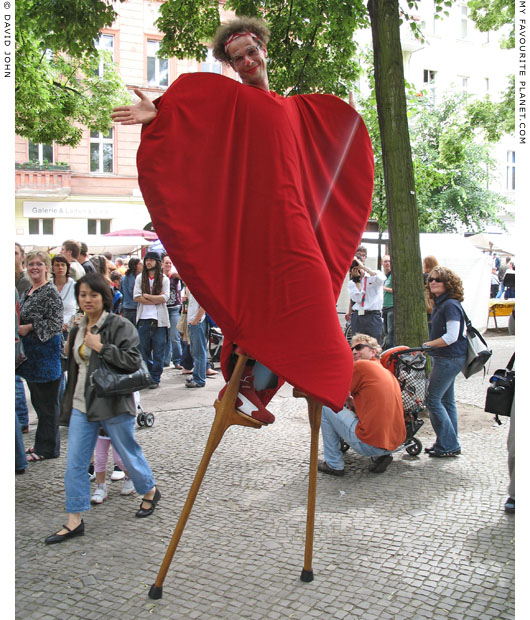 A hearty stilt-walker on Boxhagener Platz, Friedrichshain, Berlin at The Cheshire Cat Blog