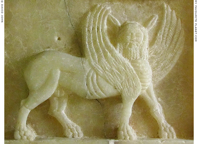 Marble relief of an ancient mythical creature from the Near East at The Mysterious Edwin Drood's Column