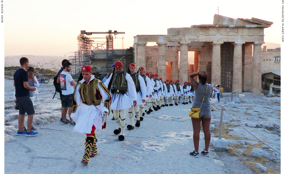 Evzones walking from the Propylaia for the daily ceremonial lowering of the Greek flag on the Acropolis at My Favourite Planet