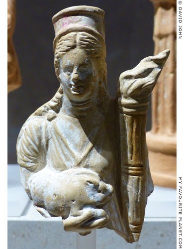 Terracotta female figure holding a piglet and a torch at My Favourite Planet