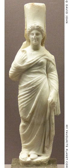 Marble statuette of Persephone wearing a high polos and holding a pomegranate flower at My Favourite Planet