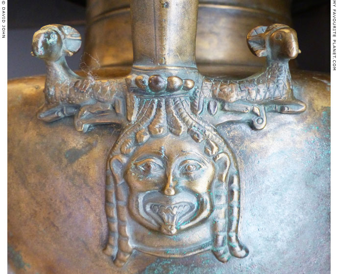 A relief of a Gorgoneion on an Archaic bronze hydria from Diasella, Elis, Greece at My Favourite Planet A relief of a Gorgoneion on an Archaic bronze hydria from Diasella, Elis, Greece at My Favourite Planet