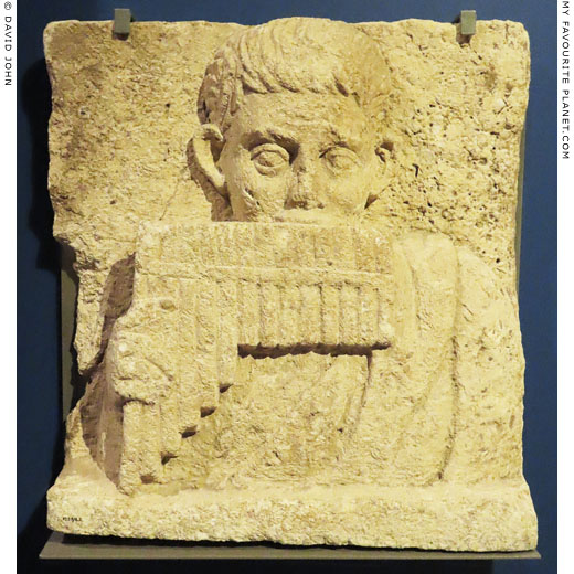 Limestone relief of a boy playing a syrinx rom Oxyrhynchus, Egypt at My Favourite Planet